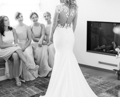 Brautpaar im Hochzeitsoutfit posiert mit Rücken zur Kamera