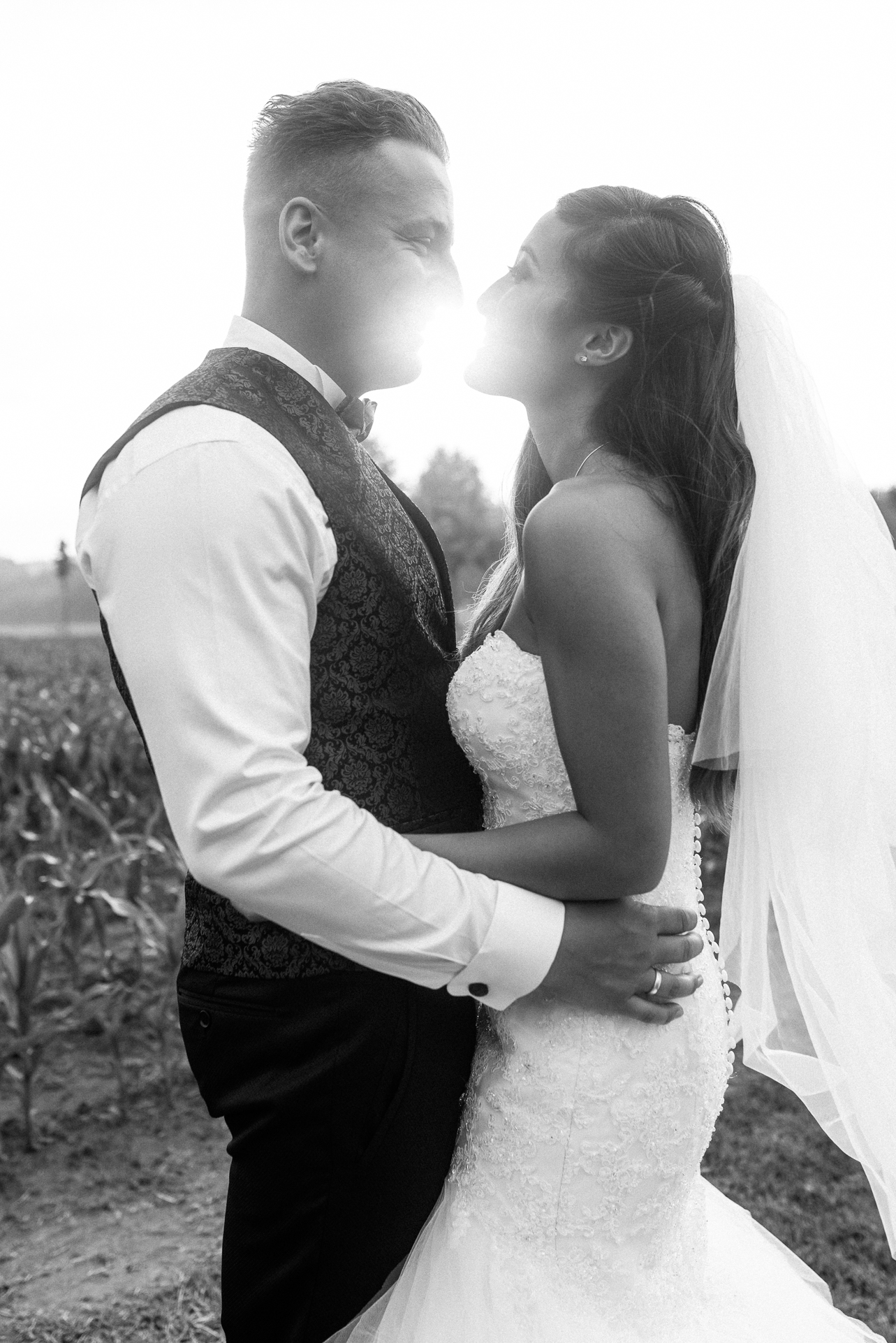 Schwarz-Weiß-Seitenportrait von Kim und Chris mit Sonnenlicht zwischen ihren Mündern von Jeean Hochzeitsfotografie